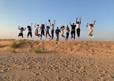 Students jumping on a sand dune