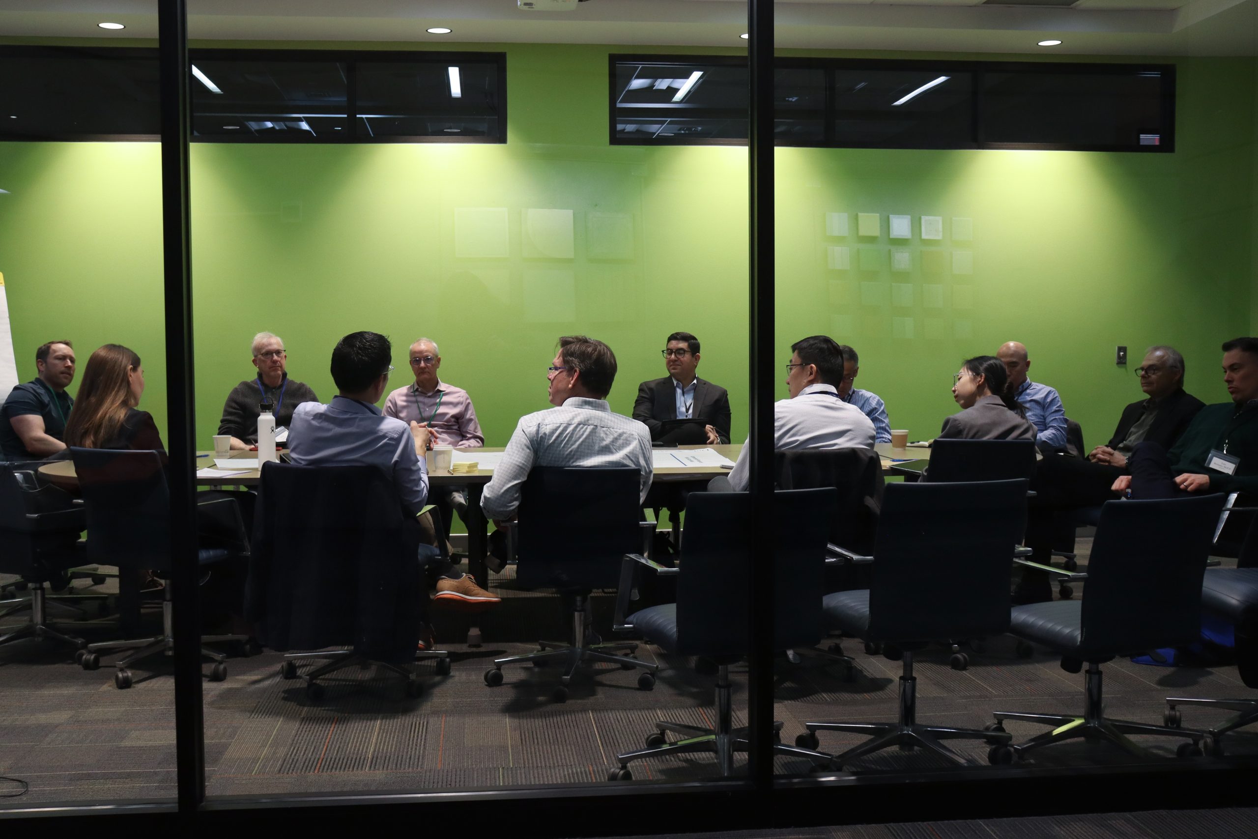 People sit around a boardroom table while someone speaks